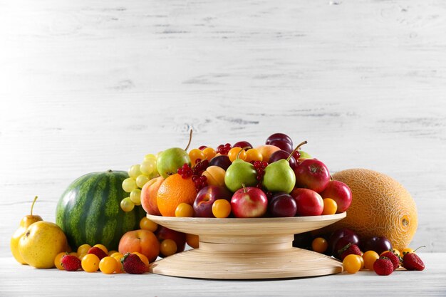 Foto mucchio di frutta fresca e bacche su fondo di legno