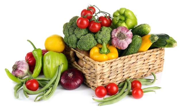 heap of fresh fruits and vegetables in basket isolated on white