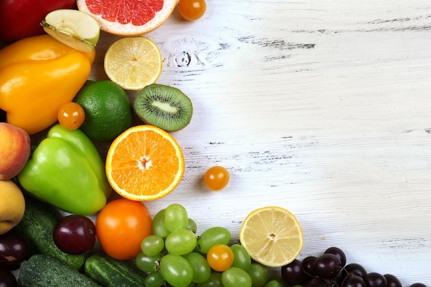 Heap of fresh fruits and vegetables on wooden background