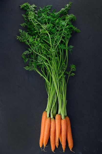 A heap of fresh organic carrot on black background. High quality photo