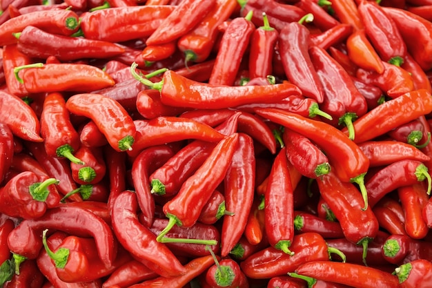 Cumulo di peperoncino rosso fresco in un mercato come sfondo.