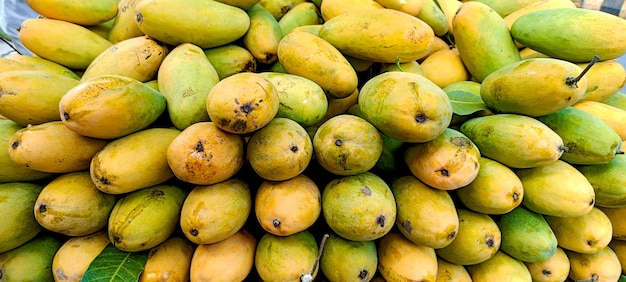 Heap of fresh ripe yellow mangoes background