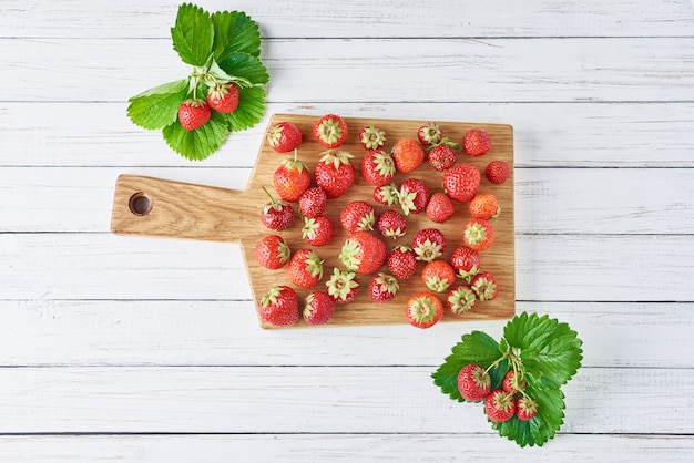 Heap of fresh strawberries with cutting board