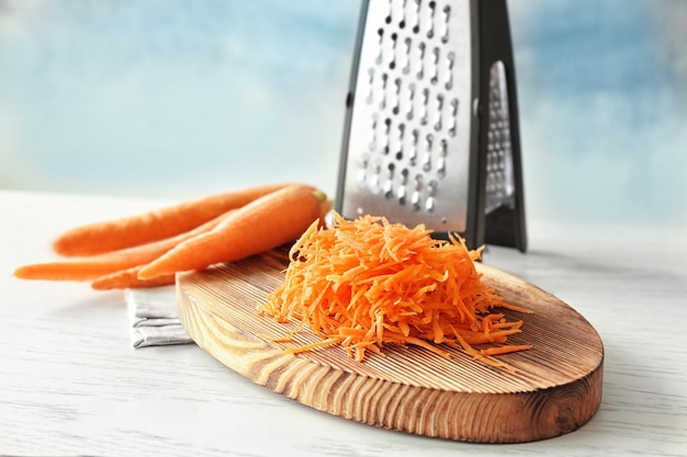 Heap of grated carrot on wooden board