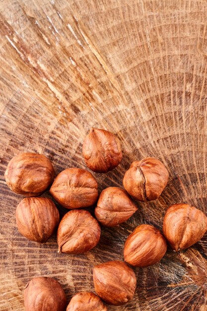 Heap of hazelnuts in shell isolated on wooden background