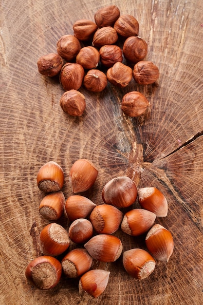 Heap of hazelnuts in shell isolated on wooden background