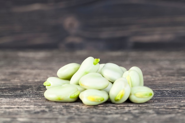 Heap of large green beans on a black table, summer harvesting and drying