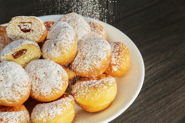 Heap of marmalade filled bismarck donuts on white plate donuts with jam