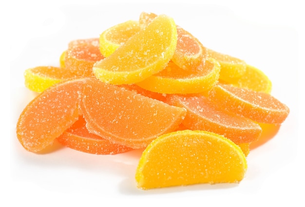 白い背景の上のオレンジとレモンのキャンディースライスのヒープ