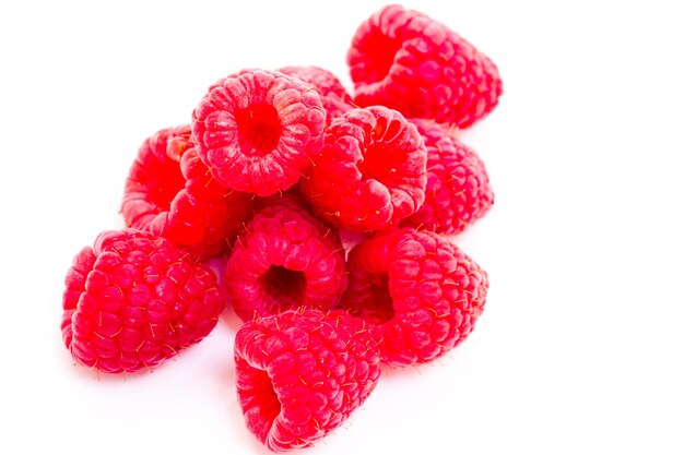 Heap of organic raspberries on white background.