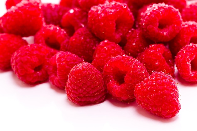 Heap of organic raspberries on white background.