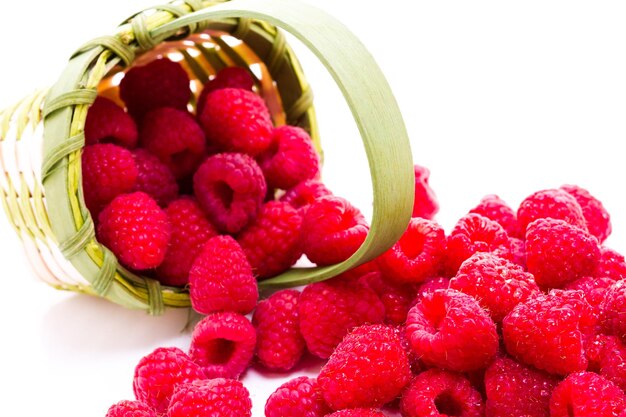 Heap of organic raspberries on white background.