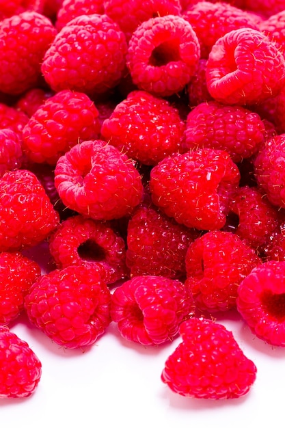 Heap of organic raspberries on white background.