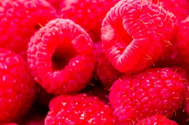 Heap of organic raspberries on white background.