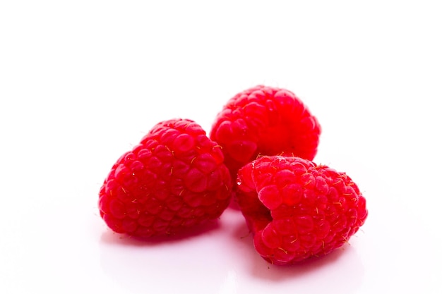 Heap of organic raspberries on white background.