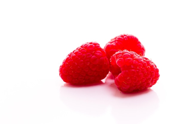 Heap of organic raspberries on white background.