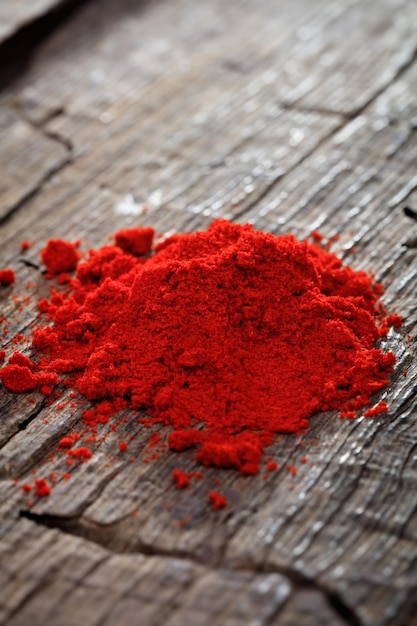 A heap of paprika powder on wooden surface