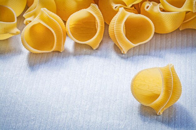 Foto mucchio di conchiglie di pasta su sfondo blu vista dall'alto concetto di cibo e bevande