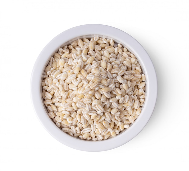 Heap of pearl barley in a bowl isolated on white background. top view