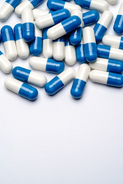 Heap of pills capsules over light grey background