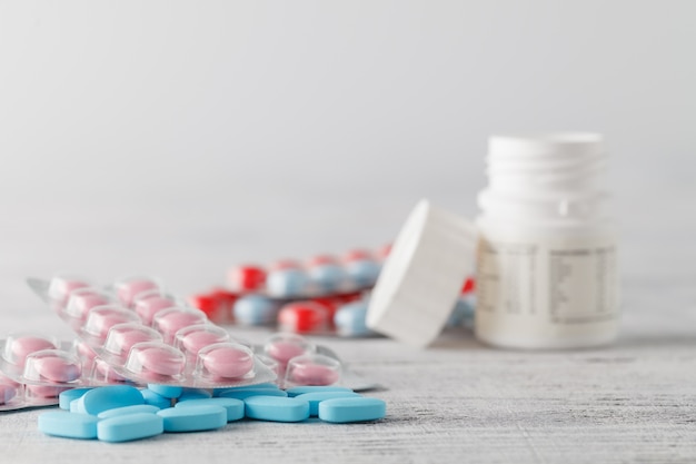 heap of pills on white wooden table