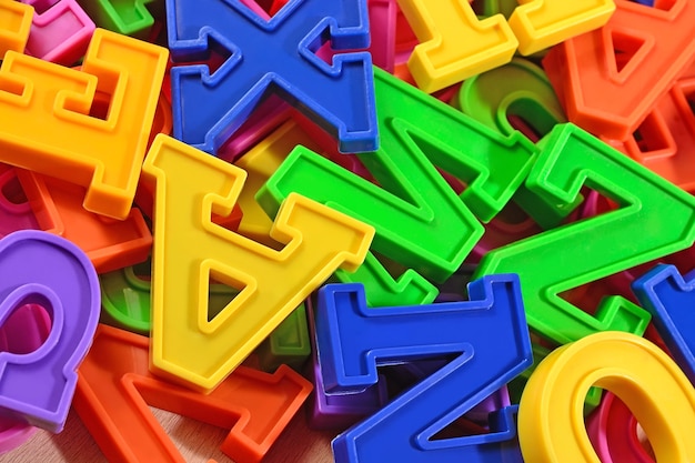 Heap of plastic colored alphabet letters close up as background