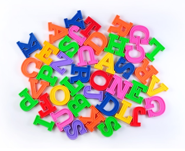 Mucchio di lettere dell'alfabeto colorate in plastica su uno sfondo bianco
