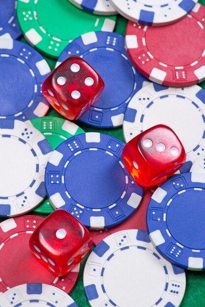 Heap of poker chips and dice on the green table