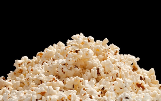 Heap of popcorn isolated on black background.