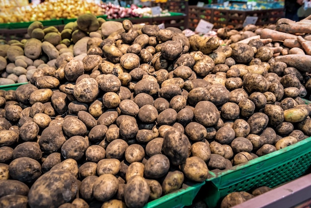 Heap of raw dirty potato in supermarket