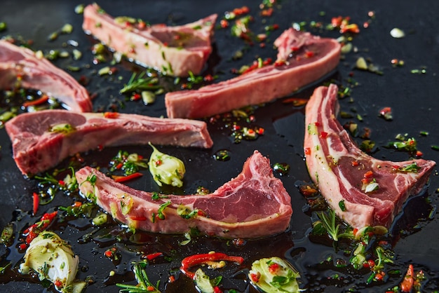 Heap of raw lamb chops with greens