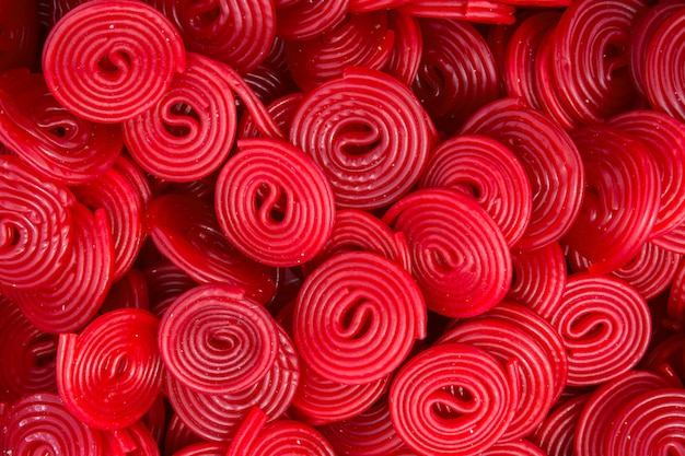 Photo heap of red strawberry licorice wheels swirls shape candies