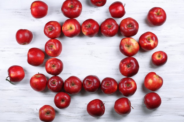 Heap of ripe red apples on wooden background