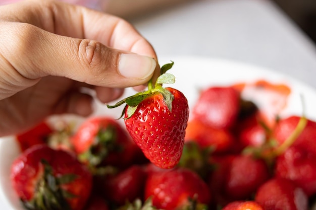 Heap of ripe red strawberries with green leaves