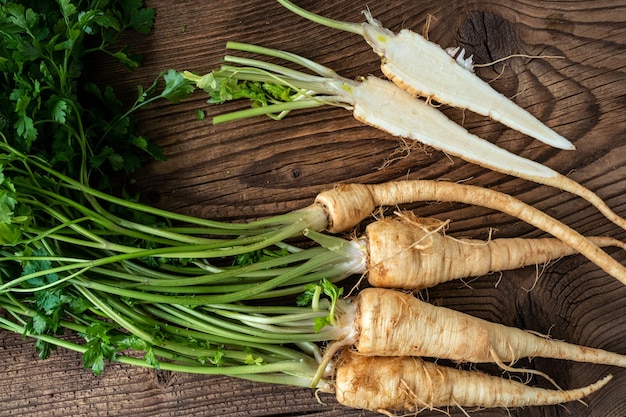 Heap roots parsley with leaves on wooden background