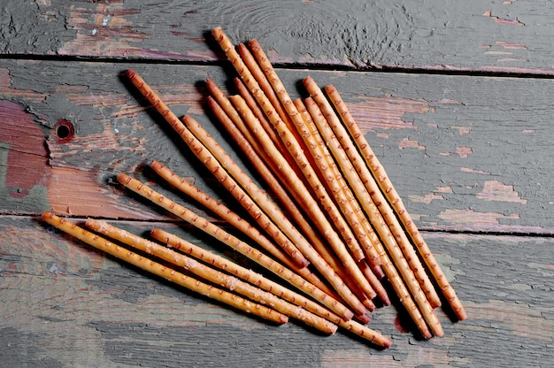 Heap salty breadsticks on dark wooden table