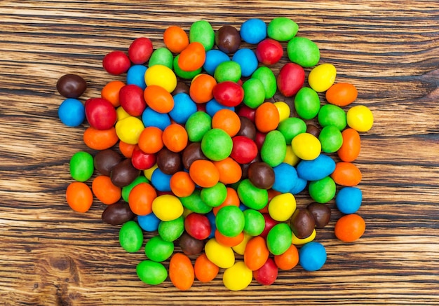 Куча сладких круглых разноцветных конфет на столе Вид сверху
