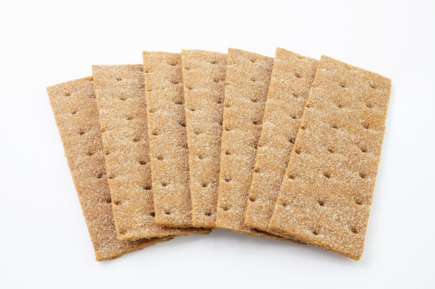 Heap of thin, crispy wholegrain rye breads isolated on white background.