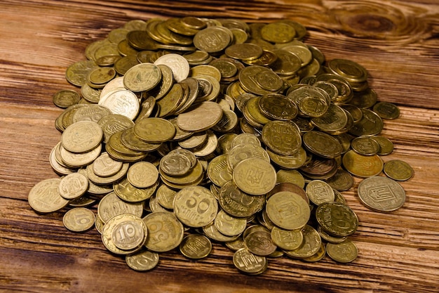 Heap of ukrainian coins on a wooden background