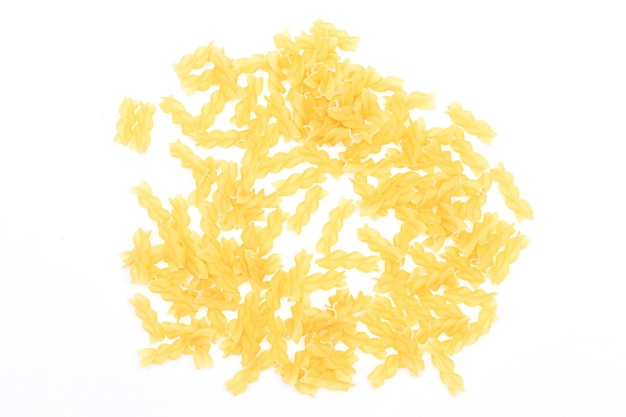 A heap of uncooked fusilli pasta scattered on white table