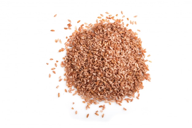 Heap of unpolished brown rice isolated on white background  