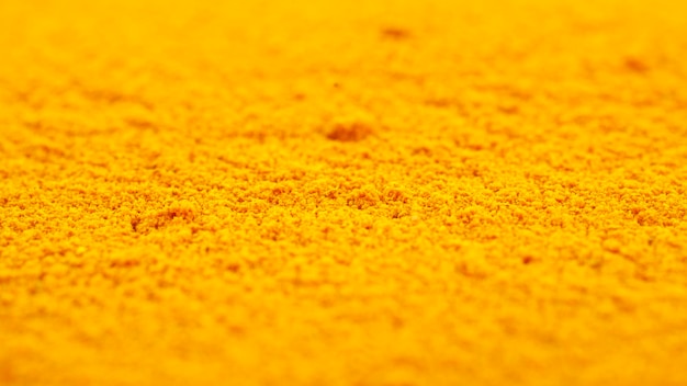 Heap van kurkuma poeder achtergrond close-up Gele kurkuma poeder textuur achtergrond Kurkuma poeder