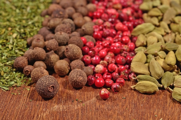 Heap of various kinds of dry spices on a wooden background