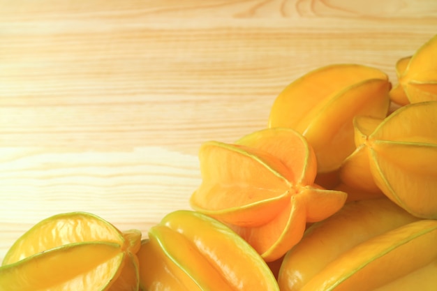 Heap of vibrant yellow ripe fresh Star Fruits on the wooden table