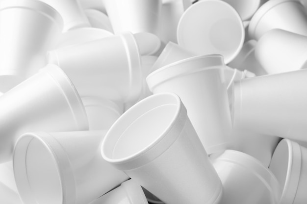 Куча белых пенопластовых чашек в качестве фона крупным планом