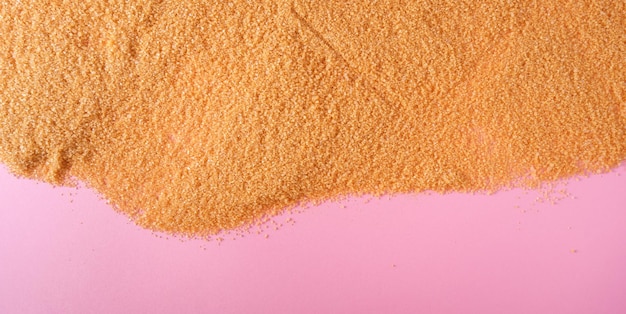 A heap with Dry sugar on pink background top viewflat lay