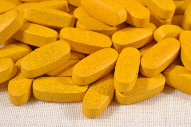 Heap of yellow pills as background texture