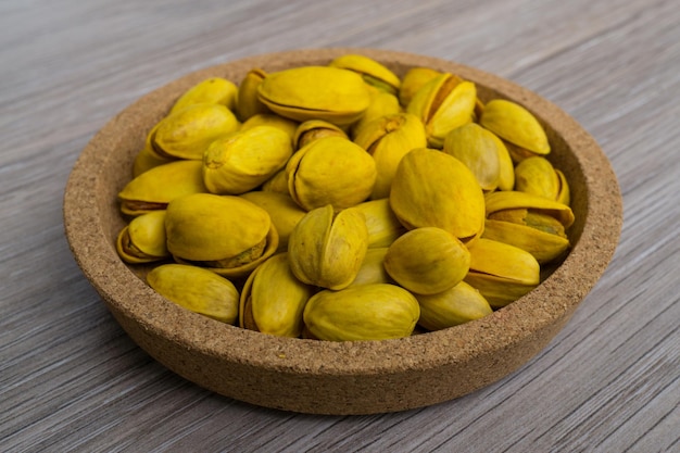 A heap of yellow pistachios on a plate