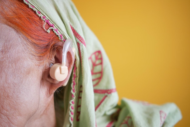 Foto concetto di apparecchio acustico una donna anziana con problemi di udito