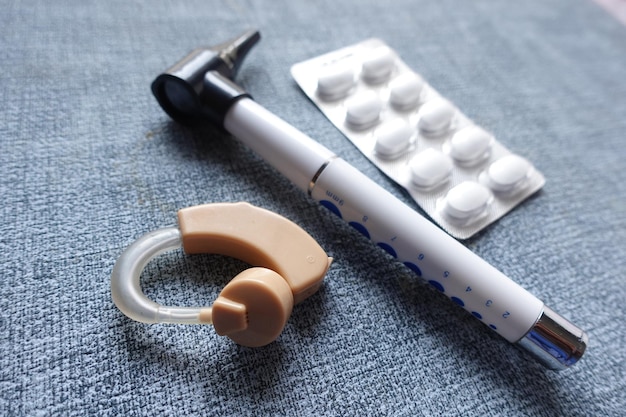 Hearing aid equipment and medical pills on table close up